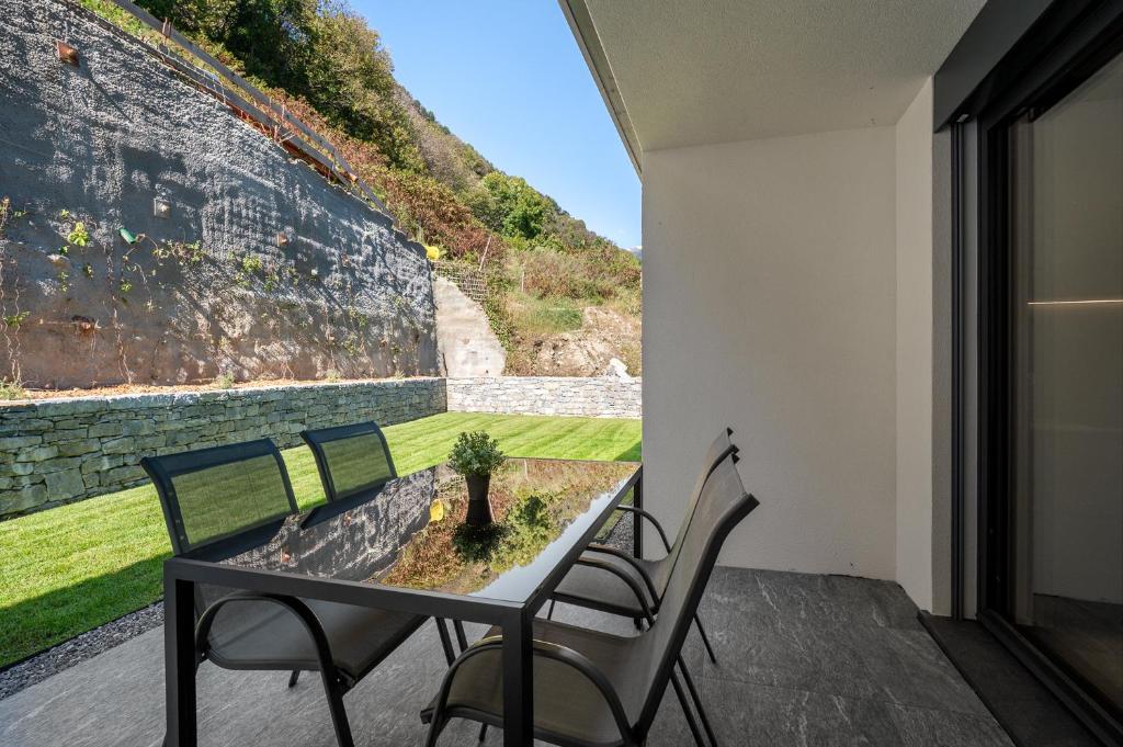Una mesa y sillas en un balcón con una pared en Terrace, Garden & Castle View, en Bellinzona