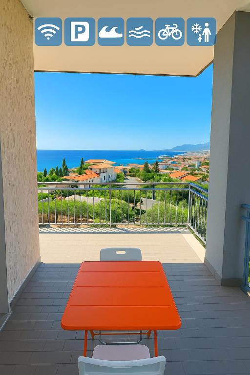 a red table and two chairs on a balcony at Pietra Ligure Sea View Parking & Bike Box in Pietra Ligure
