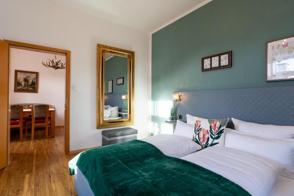 ein Schlafzimmer mit einem großen Bett und einem Spiegel in der Unterkunft Höllental heritage house - Zugspitzblick - 3 in Garmisch-Partenkirchen