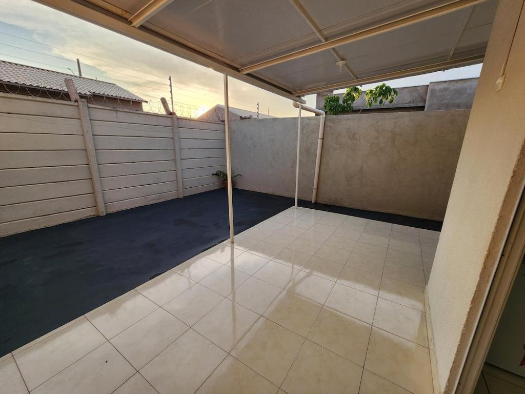 uma garagem vazia com portas de vidro e piso de azulejo em Comfortable house in a gated community em Rondonópolis