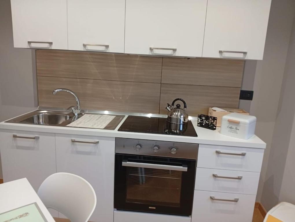 a small kitchen with a stove and a sink at House Le Treemme in Chiubbica