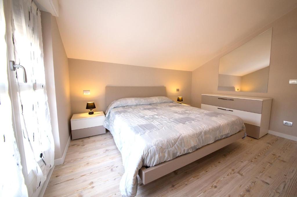 Un dormitorio con una cama y dos mesitas de noche. en Appartamenti Aosta, en Aosta