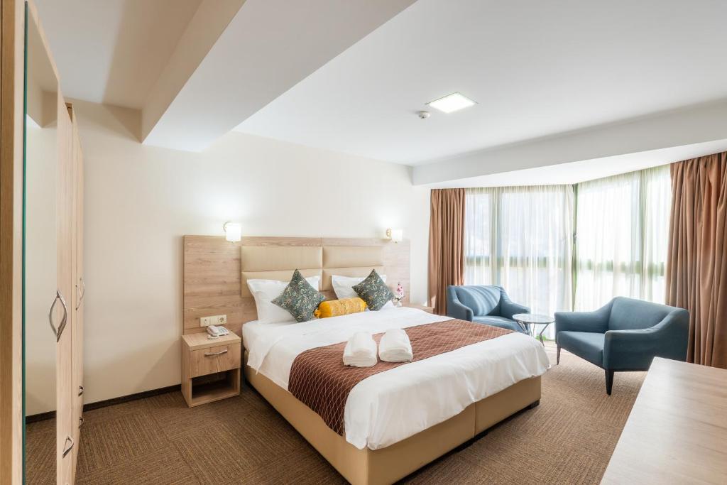 Una habitación de hotel con una cama y una silla azul. en Hotel Somi Inn, en Tiflis