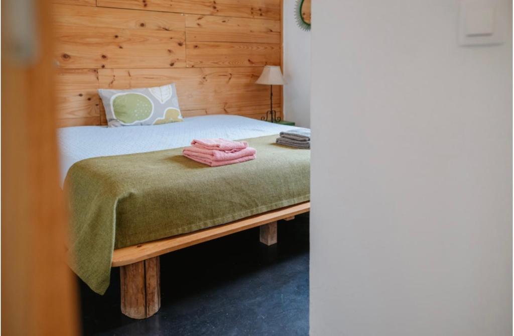a bedroom with a bed with a green blanket on it at Monte das Mariolas in Castelo de Vide