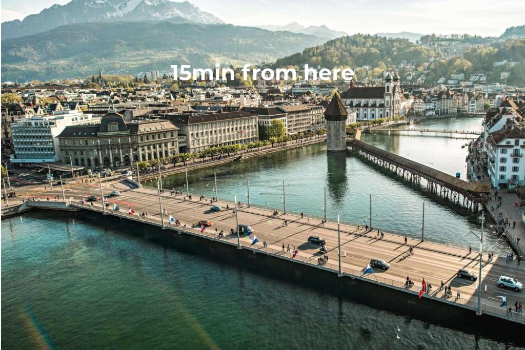a bridge over a river with a city and a town at Mount Pilatus view Apartment Lucerne with free parking & WIFI in Luzern
