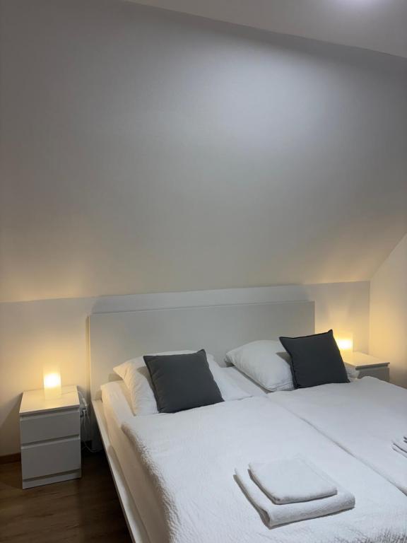 a bedroom with a large white bed with two pillows at Gasthof Wilhelm Tell bei Anna in Zirndorf