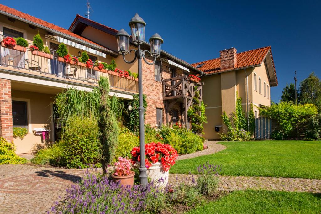 a street light in front of a house with flowers at Villa Mare Apartamenty in Grzybowo