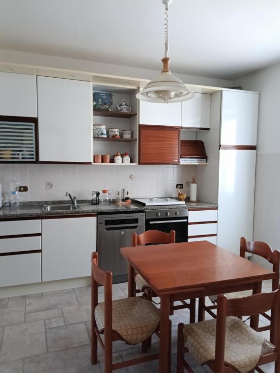 a kitchen with white cabinets and a table and chairs at Casa Bea in Castiglione