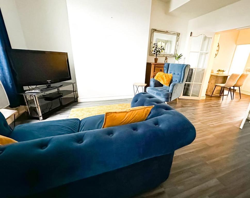 een woonkamer met een blauwe bank en een tv bij Hill View in Charlton