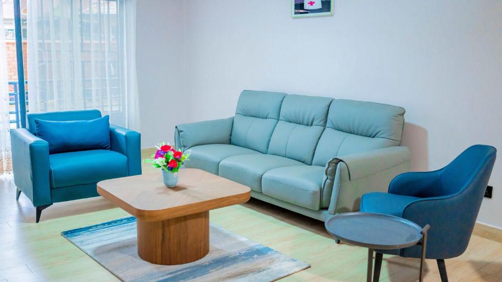 a living room with a couch and two chairs and a table at Kigali Airport Stay Apartments in Kigali