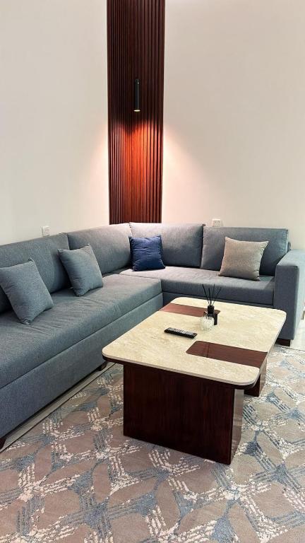 un salon avec un canapé bleu et une table basse dans l'établissement شقة راقية بغرفة نوم وصالة مريحة, à Hafr Al Baten
