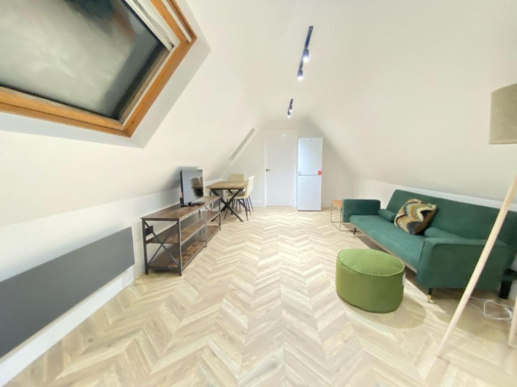 Blindley HeathにあるDippen Hall Signature Apartmentの緑のソファとテーブルのあるリビングルーム