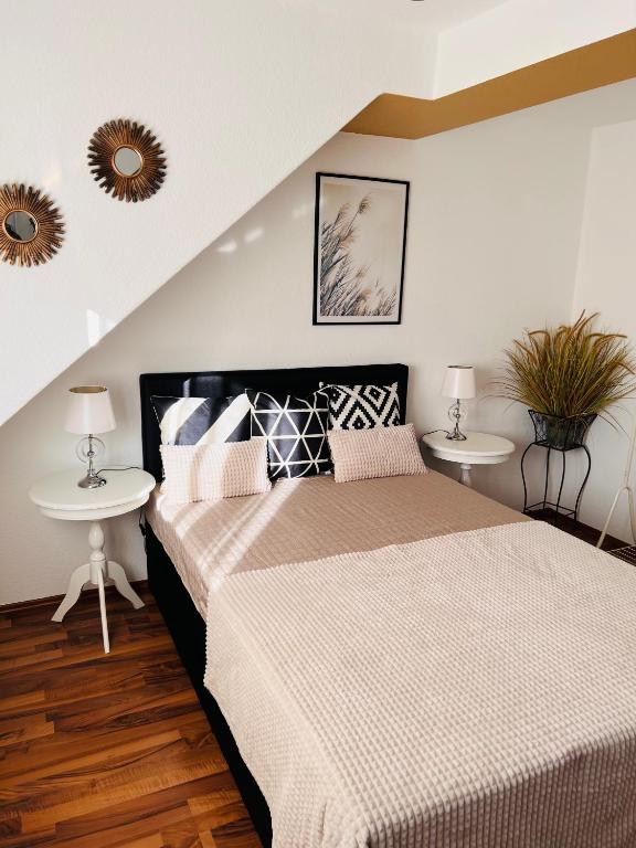 a bedroom with a bed with two tables and two mirrors at Zapfwerk-Rooms in Großbeeren