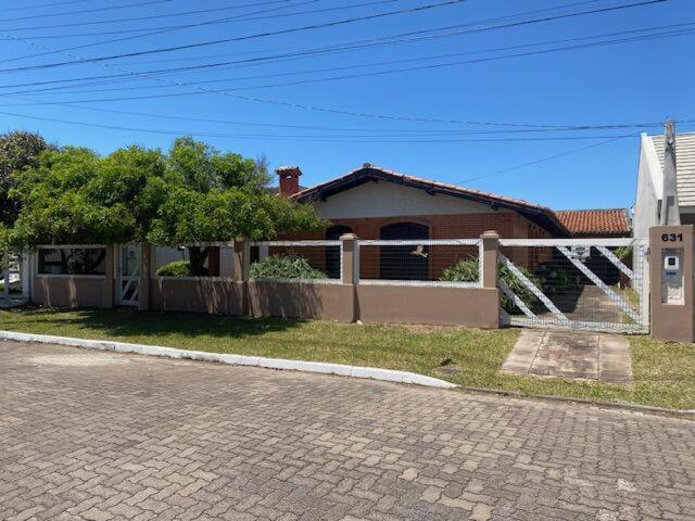 a house with a fence on the side of a street at Seu Lar em Imbè in Imbé
