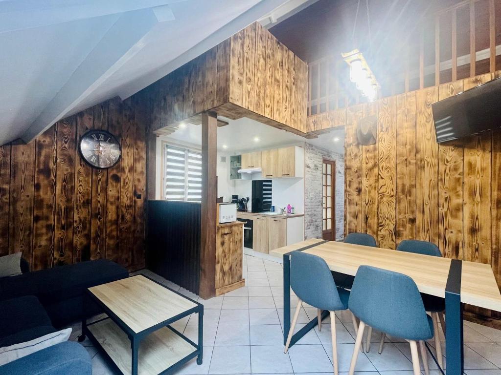 a kitchen and dining room with a table and chairs at La Grange in Carentan