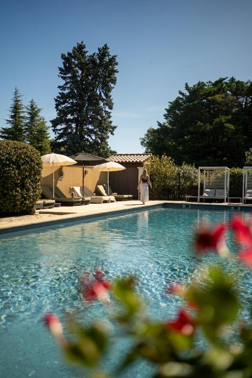 a woman standing next to a swimming pool at Villa Liberty in Entraigues-sur-la-Sorgue