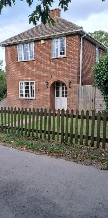 a brick house with a wooden fence in front of it at 28 Clifford Road in Whitstable