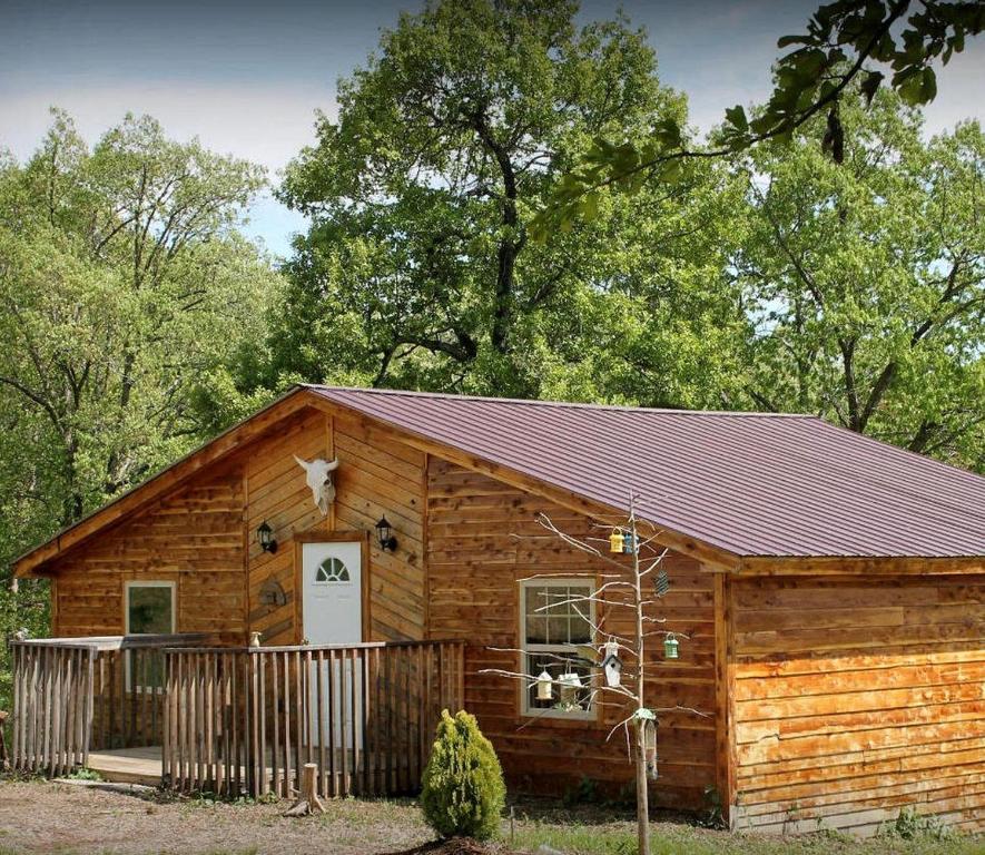 a log cabin with a porch and a white door at Farmhouse Cabin Getaway near Ozark Forest in Arkansas in Marshall