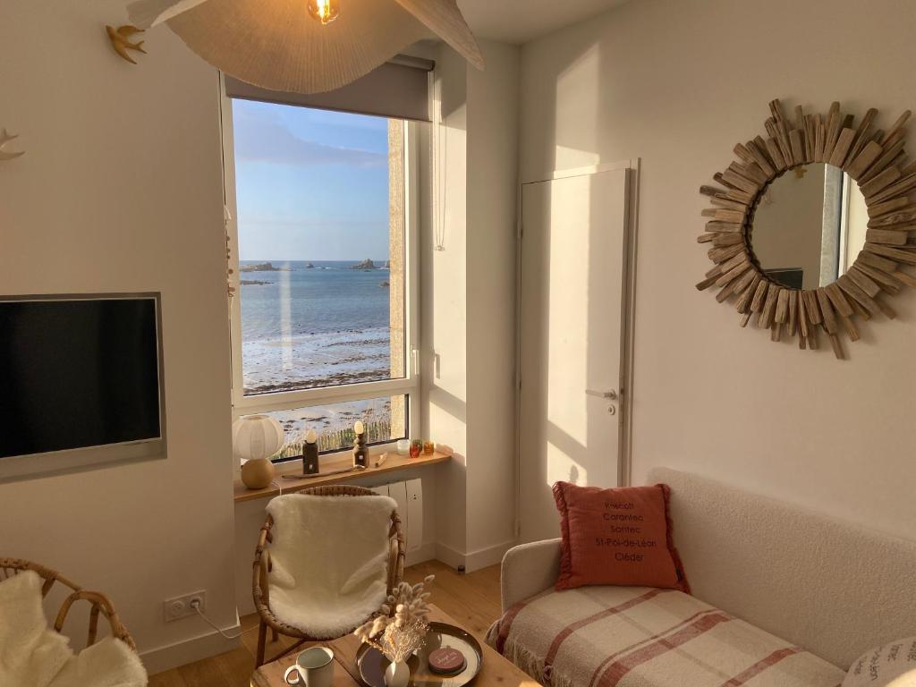 ein Wohnzimmer mit Blick auf das Meer in der Unterkunft Suite hôtelière face à la mer in Santec