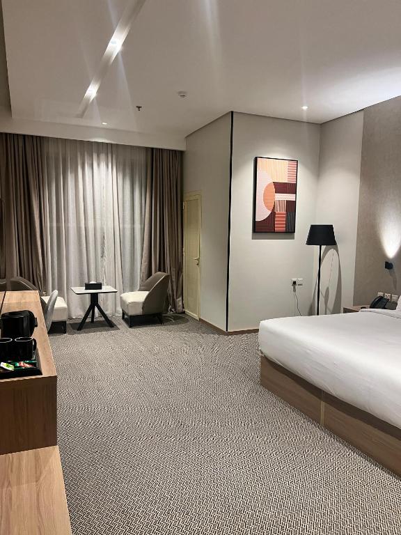 a hotel room with a bed and a desk and chair at فندق دبليو سويتس القنفذة in Al Qunfudhah
