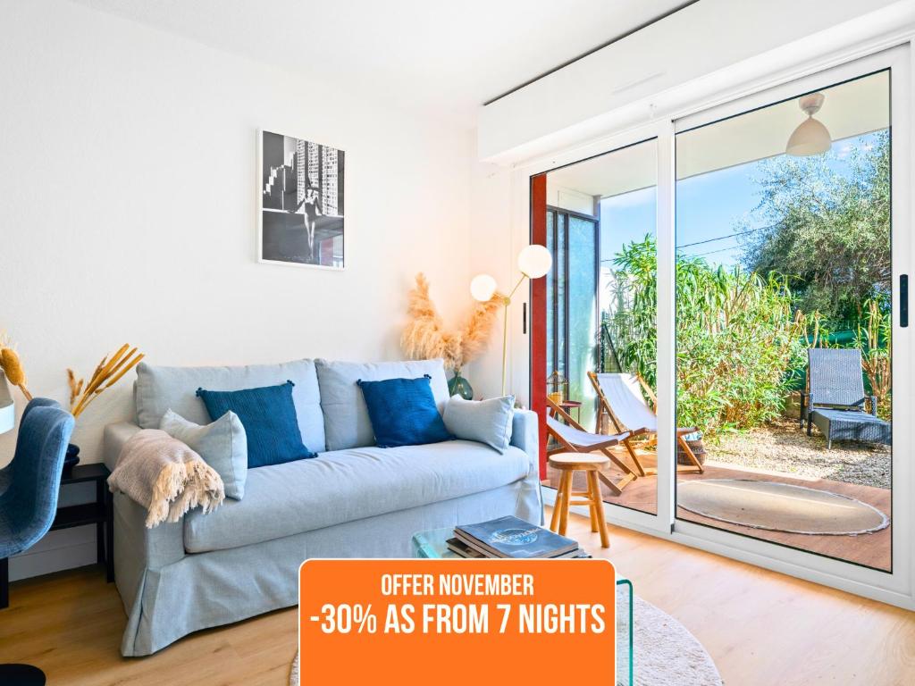 a living room with a couch and a sliding glass door at Le Cocon - 5 min to Monaco - Ideal couple or business - Free private parking - Near events - Terrace and balcony - Premium services in Fontvieille