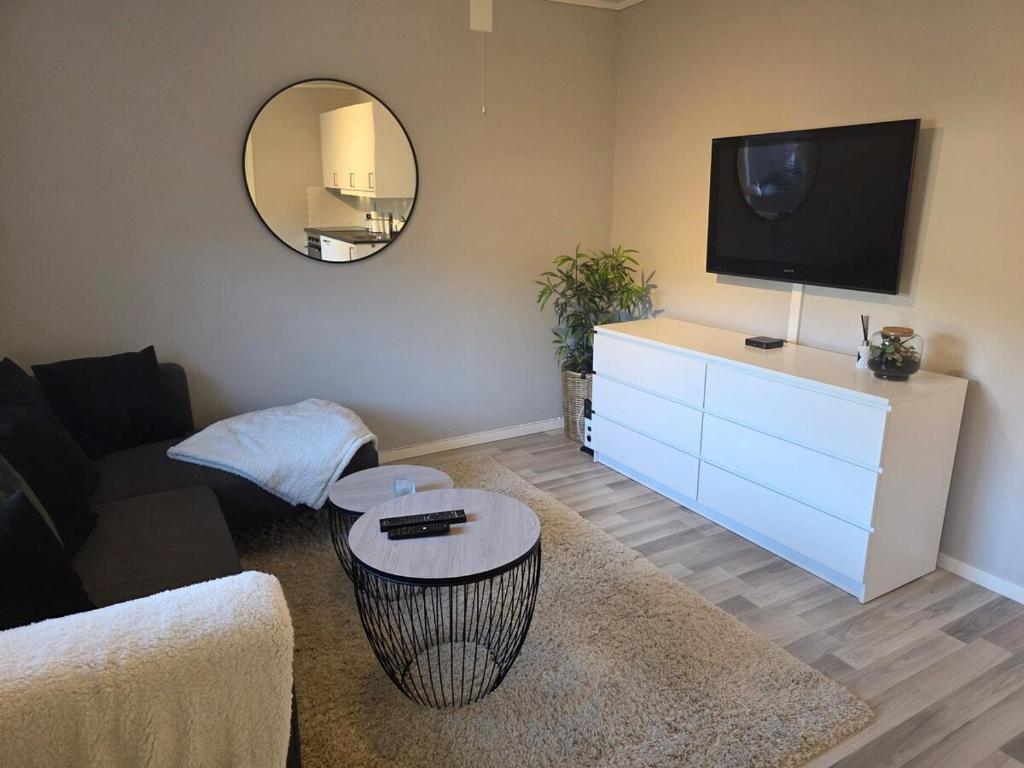 ein Wohnzimmer mit einem Flachbild-TV auf einer Kommode in der Unterkunft Apartment, Fosnavåg city center in Fosnavåg