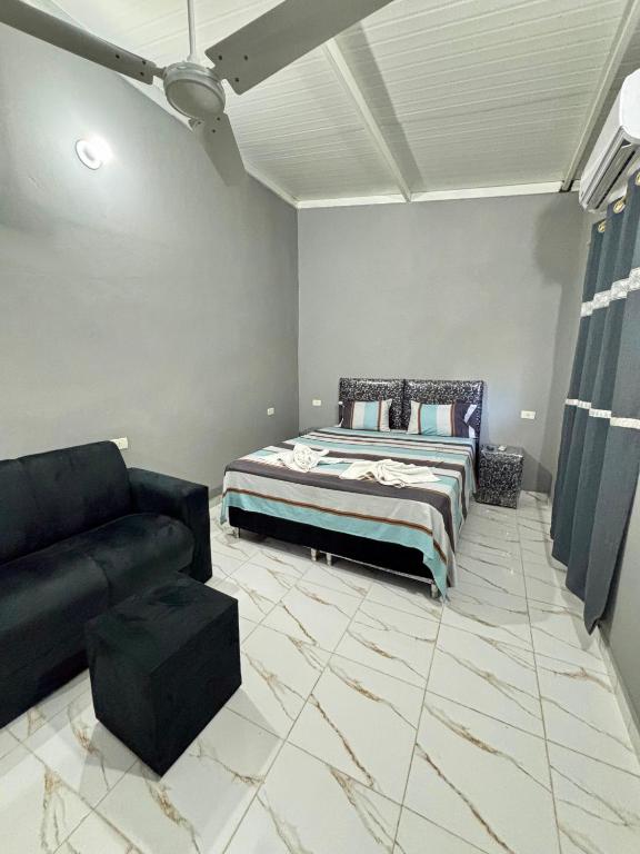 a living room with a bed and a couch at Hospedaje Paluma in Asunción