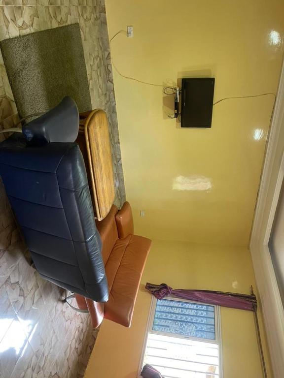 Draufsicht auf eine Couch und einen Fernseher in einem Zimmer in der Unterkunft Ebreezy1 villa 2 in Brufut