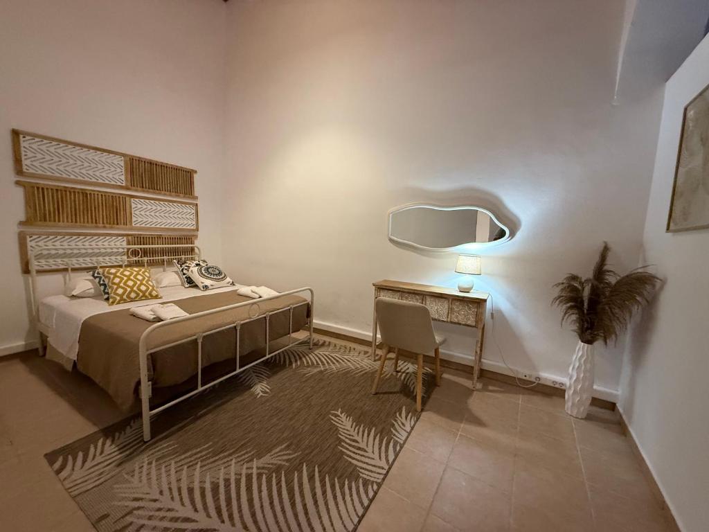 ロードス・タウンにあるEvdokia Old Town Hotelのベッドと鏡付きの机がある寝室