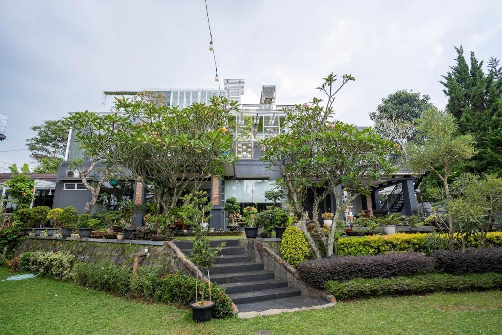 a garden with trees and stairs in front of a building at Seven Terrace in Caringin