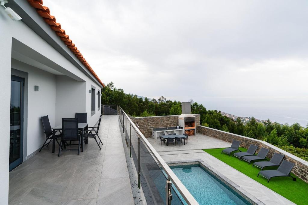 a balcony with a pool and a table and chairs at Sunny Side I Free heated pool in Tábua