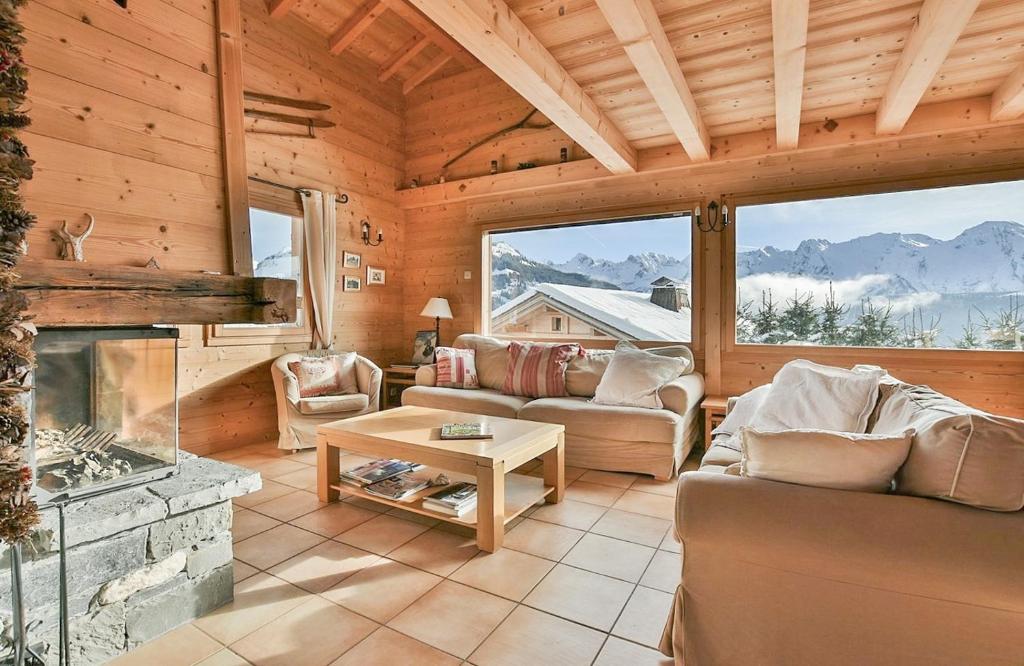 a living room with a fireplace in a log cabin at Chalet Les Sonnailles du Mont in Le Grand-Bornand