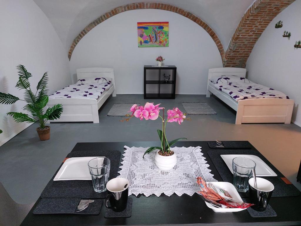 a room with two beds and a table with flowers on it at Ubytovanie Čadca in Čadca