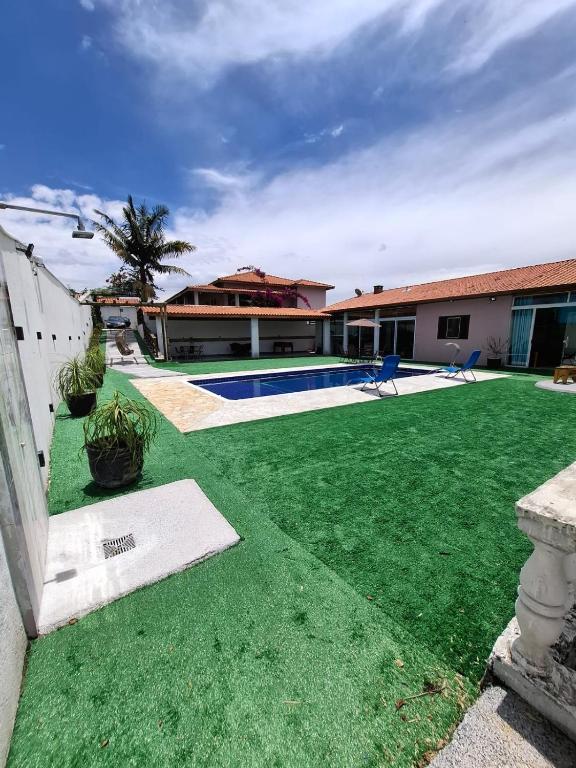 a house with a yard with a swimming pool at Chácara Sonia & Mineiro in Igaratá