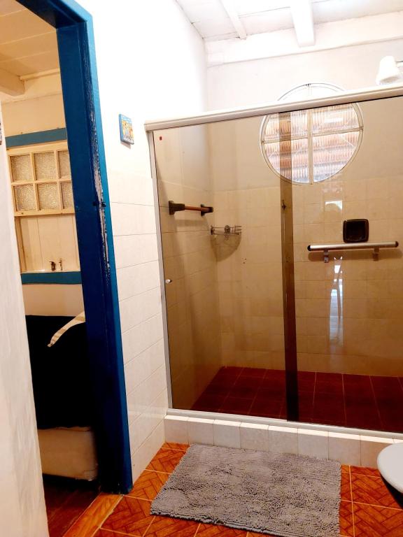 a shower with a glass door in a bathroom at Hospedagem Casa do Bem Ficar in Lumiar