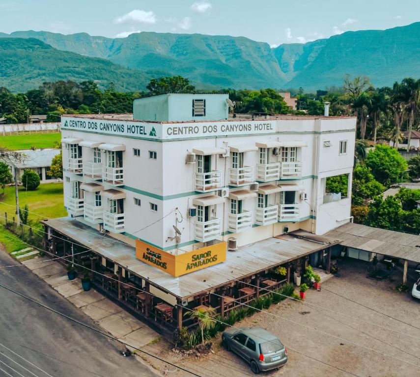 a building with a car parked in front of it at Hotel Centro dos Canyons in Praia Grande