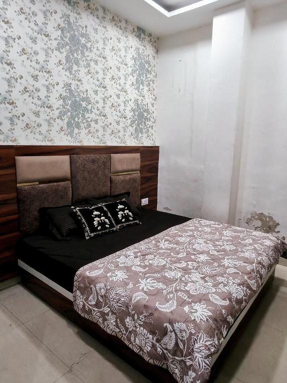 een slaapkamer met een bed met een bloemenbehang bij Hotel Morning Star in Bathinda