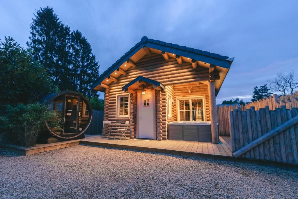 une petite cabane en rondins avec une clôture en bois dans l'établissement Cosy Cottage w/ Jacuzzi in Amazing Region, à Aywaille