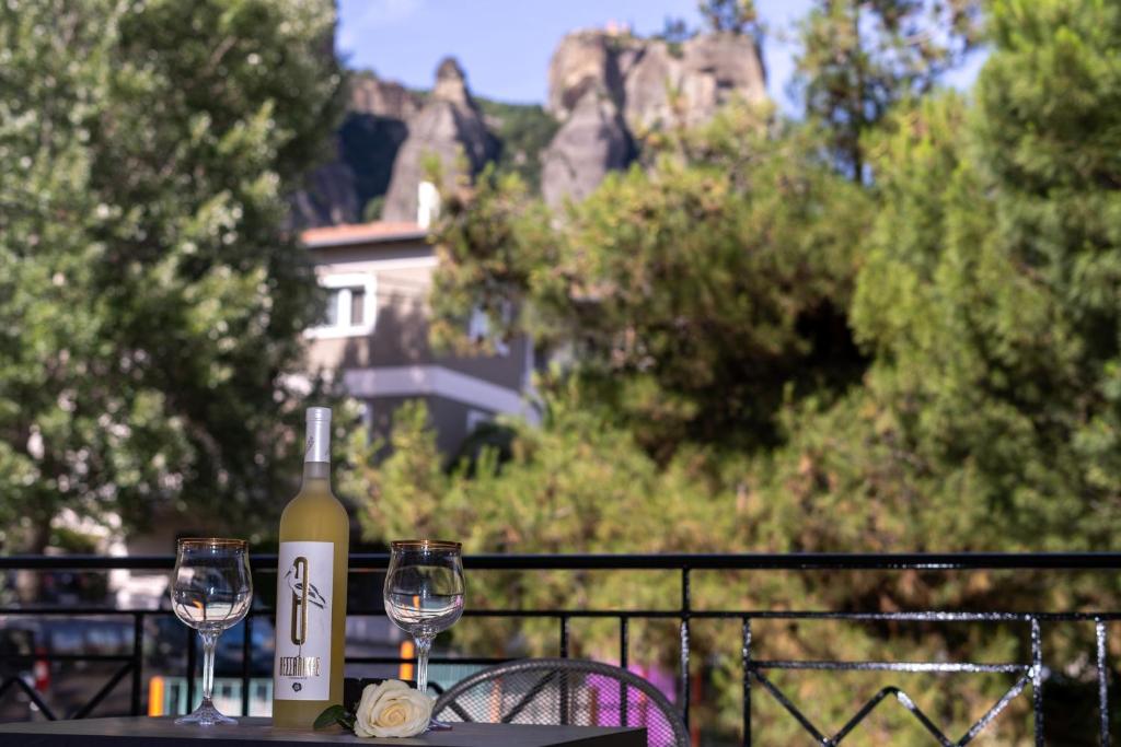 a table with a bottle of wine and two glasses at I & G Family Apartment in Kalabaka