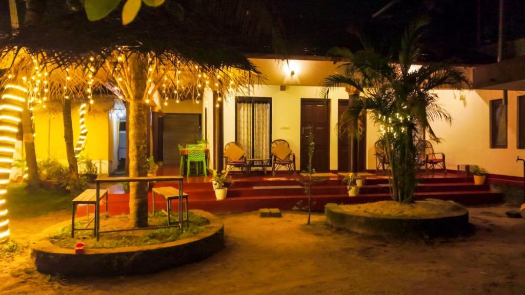 a house with two palm trees in front of it at Marari Beach La Vista in Mararikulam
