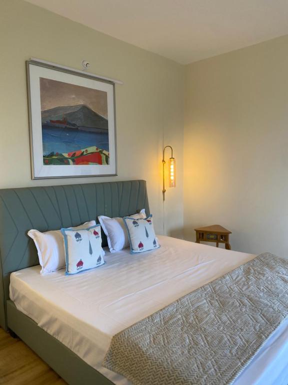 een slaapkamer met een bed met witte lakens en kussens bij 360 Agonda in Agonda