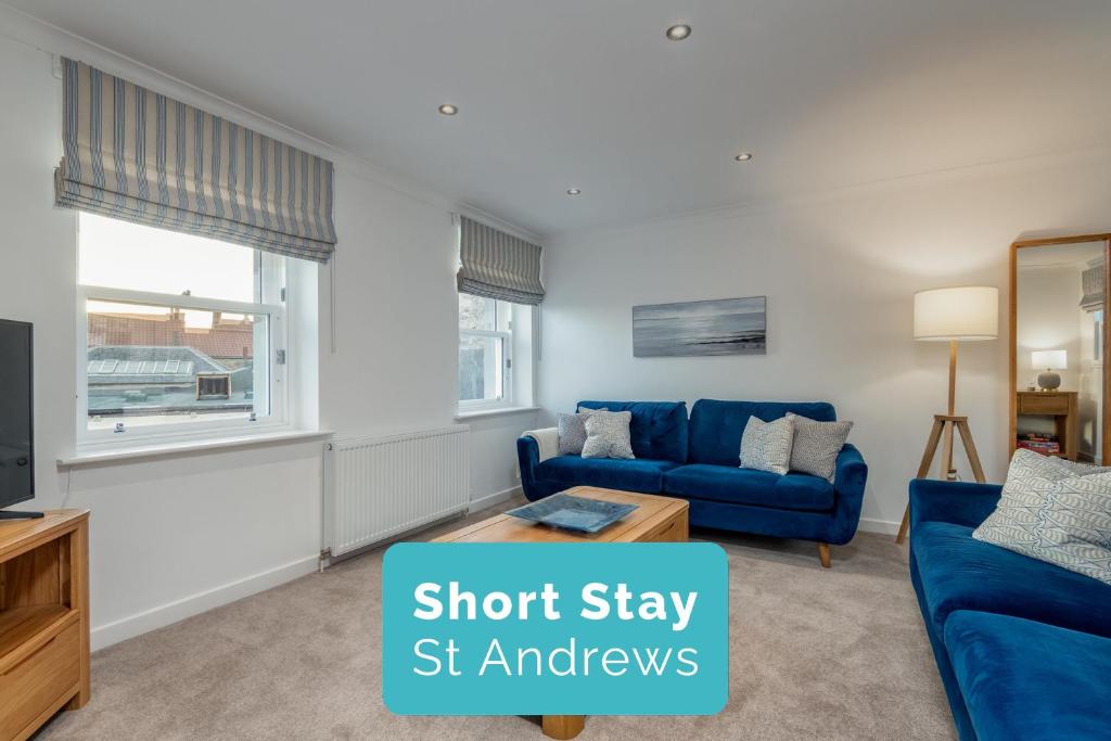 a living room with a blue couch and a tv at Murray's Neuk in Anstruther