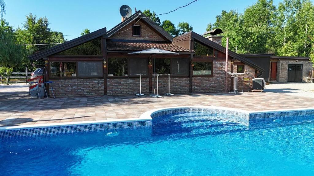 a house with a swimming pool in front of a house at Ranč Lipe in Orašje