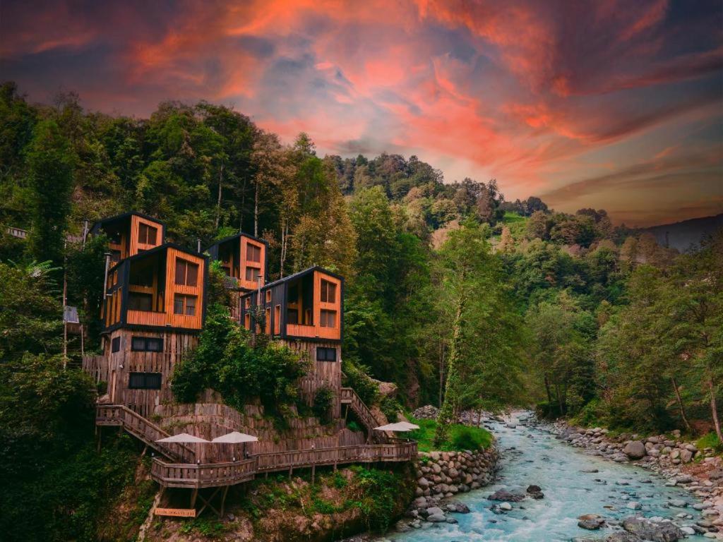 a building on the side of a river with a bridge at Saffire Doğa Evleri in Güneyköy