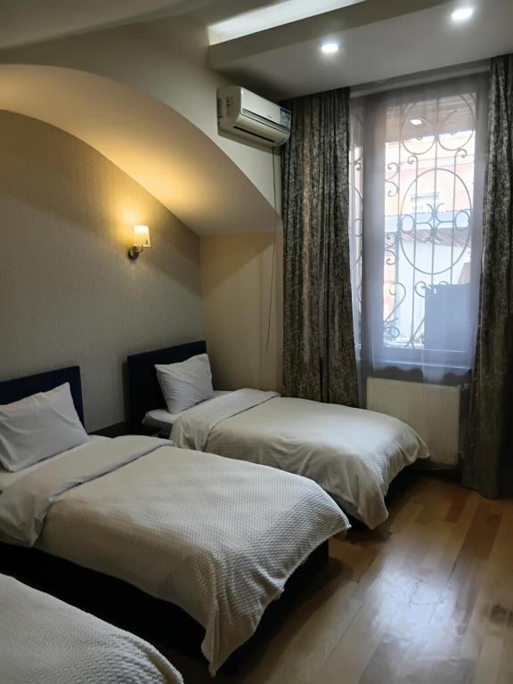 two beds in a room with a window at K17 mini hotel in Tbilisi City
