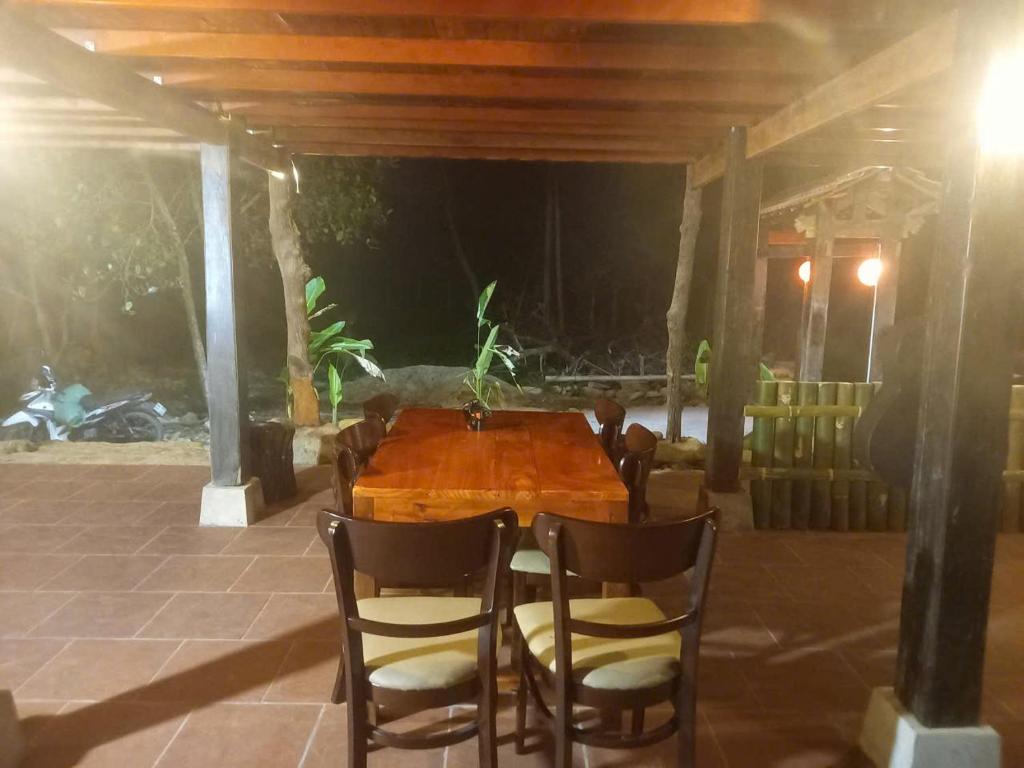 a wooden table and chairs on a patio at Tay Na Bon Homestay in Làng Lap