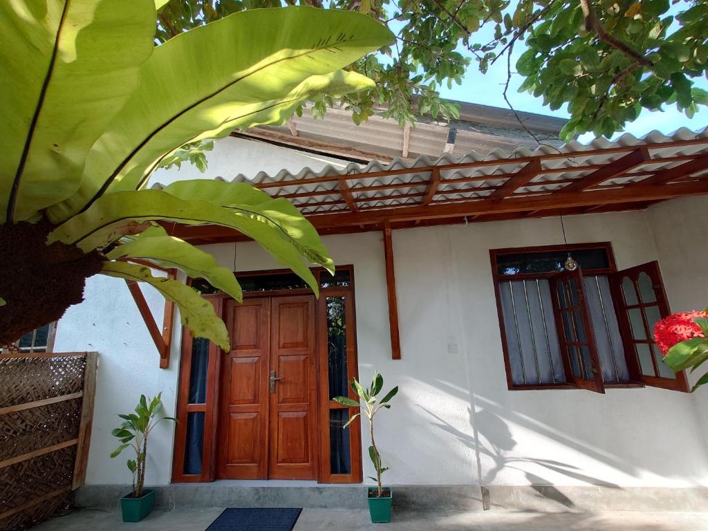 une maison avec une porte en bois et une plante dans l'établissement Eco Heaven House, à Ahangama