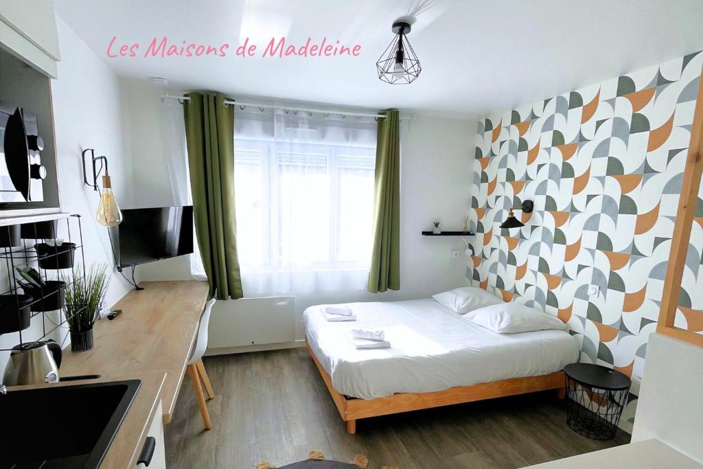 een kleine slaapkamer met een bed en een raam bij Les studios de l'Albatros in Saint-Nazaire