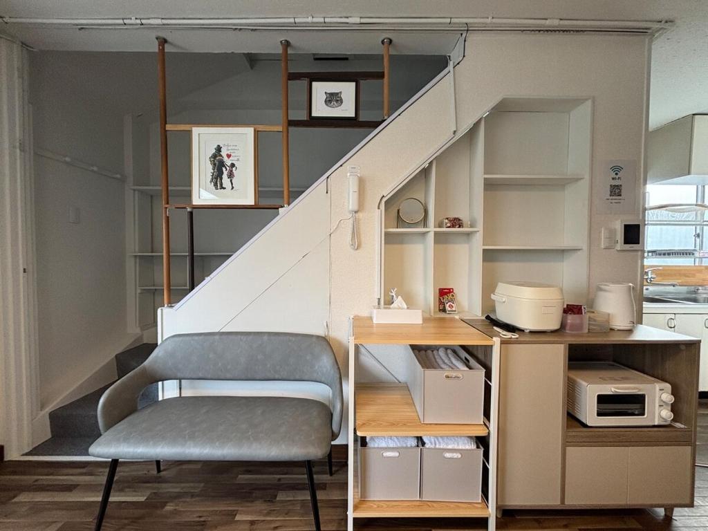 a room with a staircase with a chair and a desk at とまるん桜山 in Nagoya