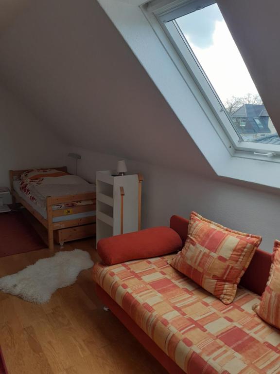 a attic room with a couch and a window at Ferienwohnung Ferienzimmer,nahe Rostock, Bentwisch Ot Albertsdorf bis 7 Personen in Bentwisch